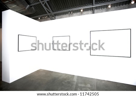 Three empty frames on white wall in museum