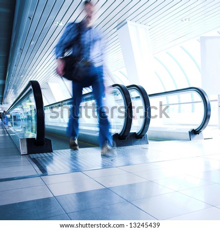 Man move in glass corridor in airport