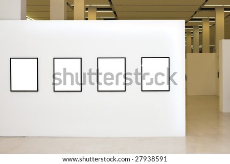 Exhibition in museum with four empty frames on white walls
