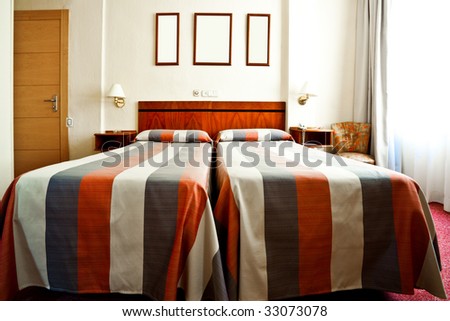 Hotel bedroom interior with bads, lamps and frames on the wall