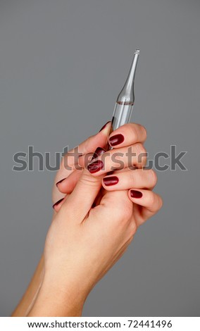 AÂ�mpule in a hands isolated on a grey background
