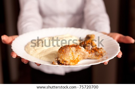 The young girl allow plate with mashed potatoes with a chicken close up