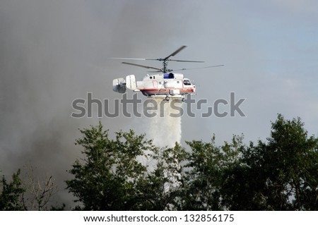 fire fighting helicopters drops water on the fire