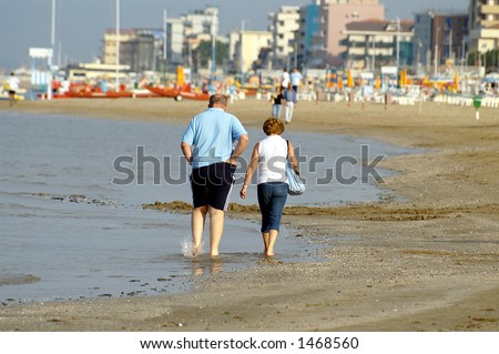 Old couple walking by Adriatic coast, Bellaria, Italy