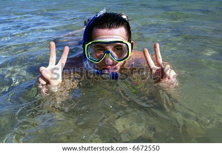 A young man with snorkel and mask at the sea