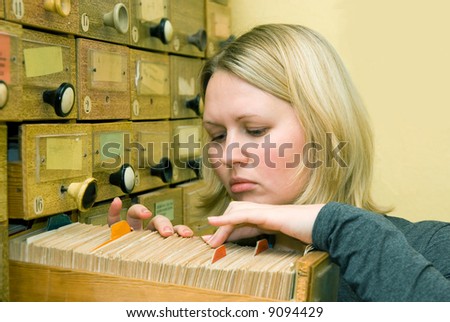 Young student girl working with library card index