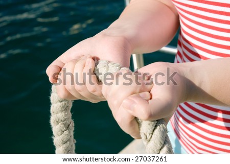 Woman`s hands holding a thick rope