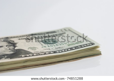 Close up photo of a stack of US banknotes. Use of selective focus to emphasize the word DOLLARS.
