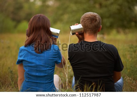 young girl and man playing with tin. outdoor shot