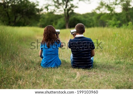 young girl and man playing with tin. outdoor shot