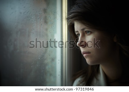 lonely girl near window thinking about something