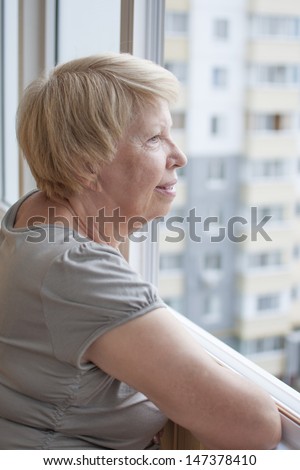 Elderly woman look out the window