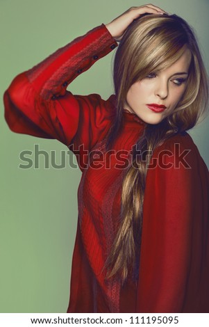 beautiful young woman with long blond hair in a braid wearing romantic red antique silk blouse