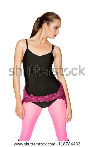 beautiful young woman in black dance leotard and bright pink tights on white studio background