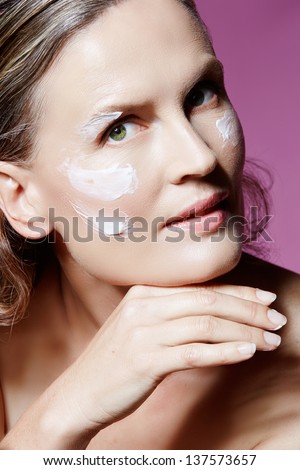 Portrait of a beautiful 40 year old woman with cream facial on her natural skin