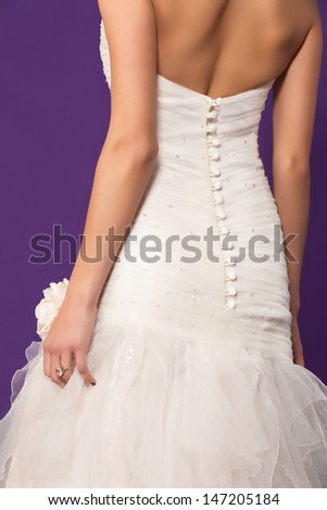 bride wearing silk dress - closeup on the button details on her back and the ruffles skirt