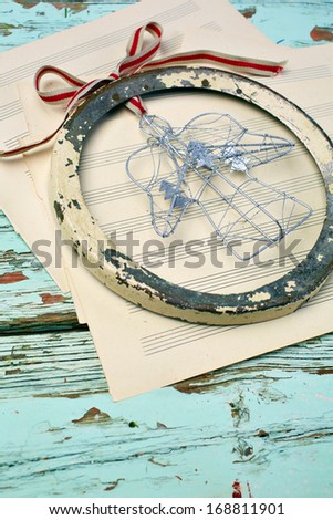 Christmas rustic angel decoration on empty sheets of music and vintage table background