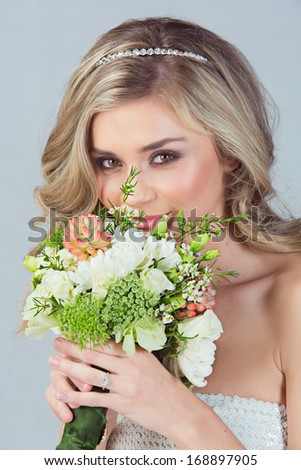 Portrait of a beautiful blond bride with a diamante headpiece. Hair in loose curly style. Wearing sequin modern dress