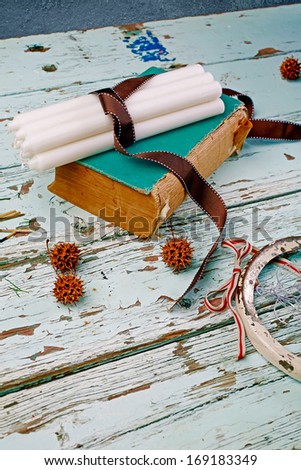 Candles tied with ribbon on antique book placed on the old grunge table background