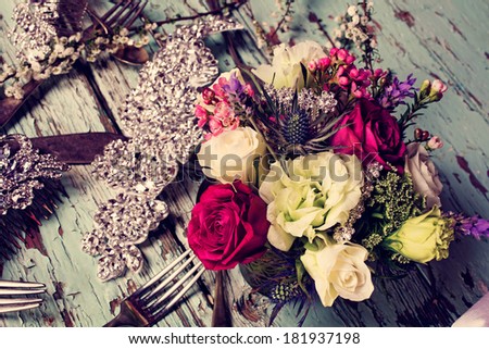Fresh roses and white flower bouquets in romantic style on grunge table with bridal jewelry