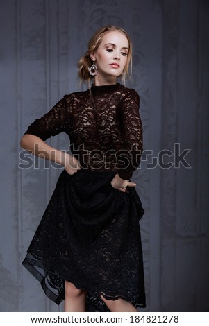Beautiful Caucasian model with blond messy hair. Standing in lace dress against Italian grunge background