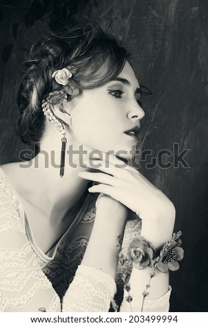 portrait of a beautiful woman with hair in braided hairstyle and flowers in her hair. wearing leather orange bracelet grunge painted background