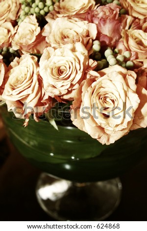 bunch of fresh orange roses in a glass vase - soft sepia