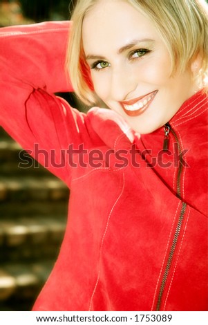 Happy blond woman with short hair in red jacket - laughing in the afternoon sun