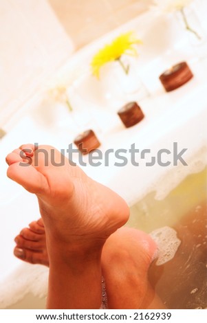 White bath tab with tanned feet of a young woman