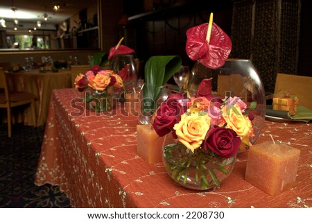Main table decorated with variety of roses and embroidered tablecloth