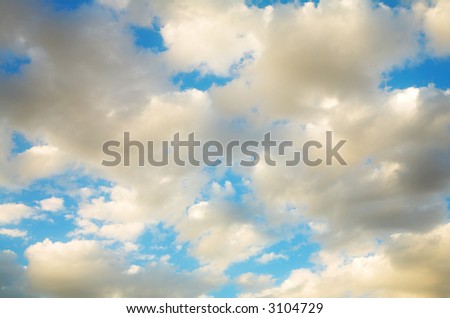 Abstract blue sky shot with soft clouds and golden glow