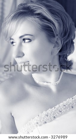 Beautiful bride with short blond hair in pearl beaded dress and soft make-up - in cold sepia finish