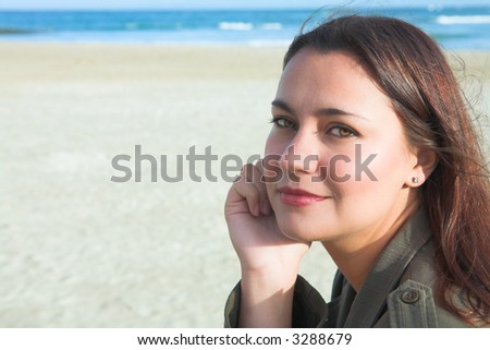 Beautiful woman with long brown hair and soft smile on beach. ISO 100, no sharpening