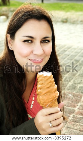 Beautiful woman, long brown hair, naughty smile eating caramel ice-cream . ISO 125, no sharpening
