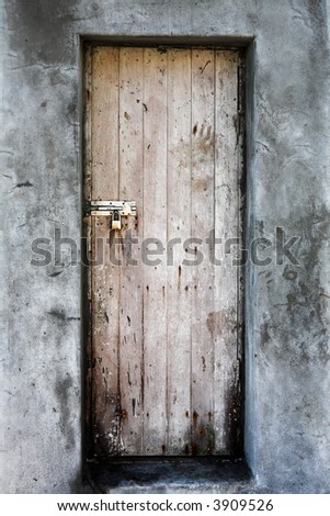 Grunge wooden door framed by plaster cement walls with cracks and dents