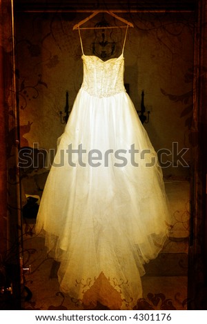 stock photo Grunge wedding dress with tulle skirt hanging in a doorway on