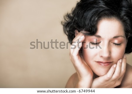 Face of a smiling woman with black curly hair, in her mid 30s with natural make-up and realistic skin texture with small fine lines