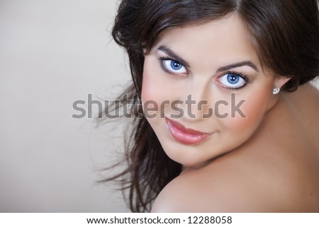 beautiful woman with brown hair, natural make-up and soft smile in her early 20s