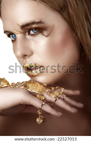 woman with gold leaf lips and gold bracelet visible moisture on her face