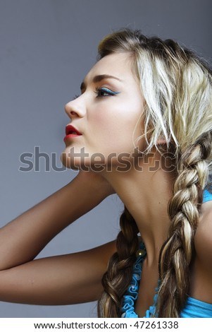 beautiful young woman in turquoise dress with long blond braids