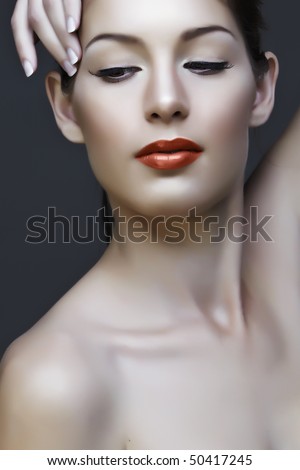 beautiful natural woman with false lashes and classic make-up with coral lipstick