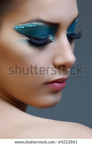 Beautiful brunette woman with cat eyes make-up in bright blue and white.