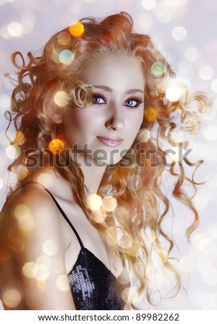 beautiful young woman with hair blowing in wind and sparkling bokeh lights background