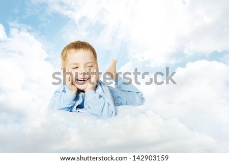 Smiling child lying down on cloud pillow over sky background