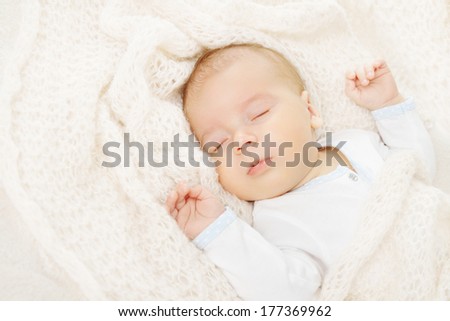 newborn baby sleeping, covering in soft woolen blanket