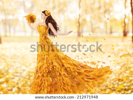 Autumn woman in fashion dress of fall maple leaves, artistic portrait in yellow gown