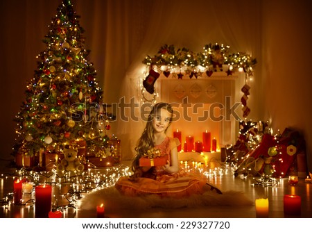 Christmas Child Girl Greeting Present Gift Box, Kid In Xmas Room With Candles Lights, Holiday Tree Illuminated By Garland
