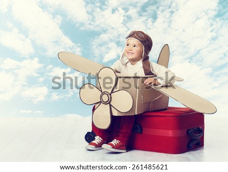 Little Child Playing Airplane Pilot, Kid Traveler Flying in Aviator Helmet on Travel Suitcase, Vacation Trip Concept over Blue Sky Clouds