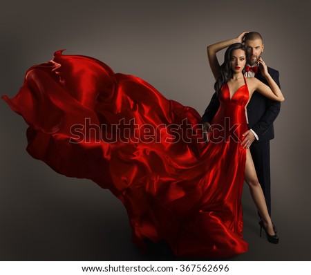 Fashion Couple Portrait, Woman Red Dress, Man in Suit, Long Waving Cloth Flying over Gray