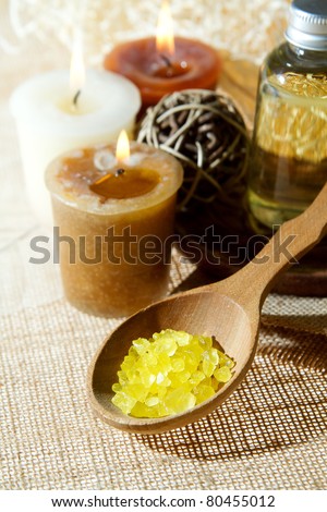 Spa aroma salt in wooden spoon and aroma candles